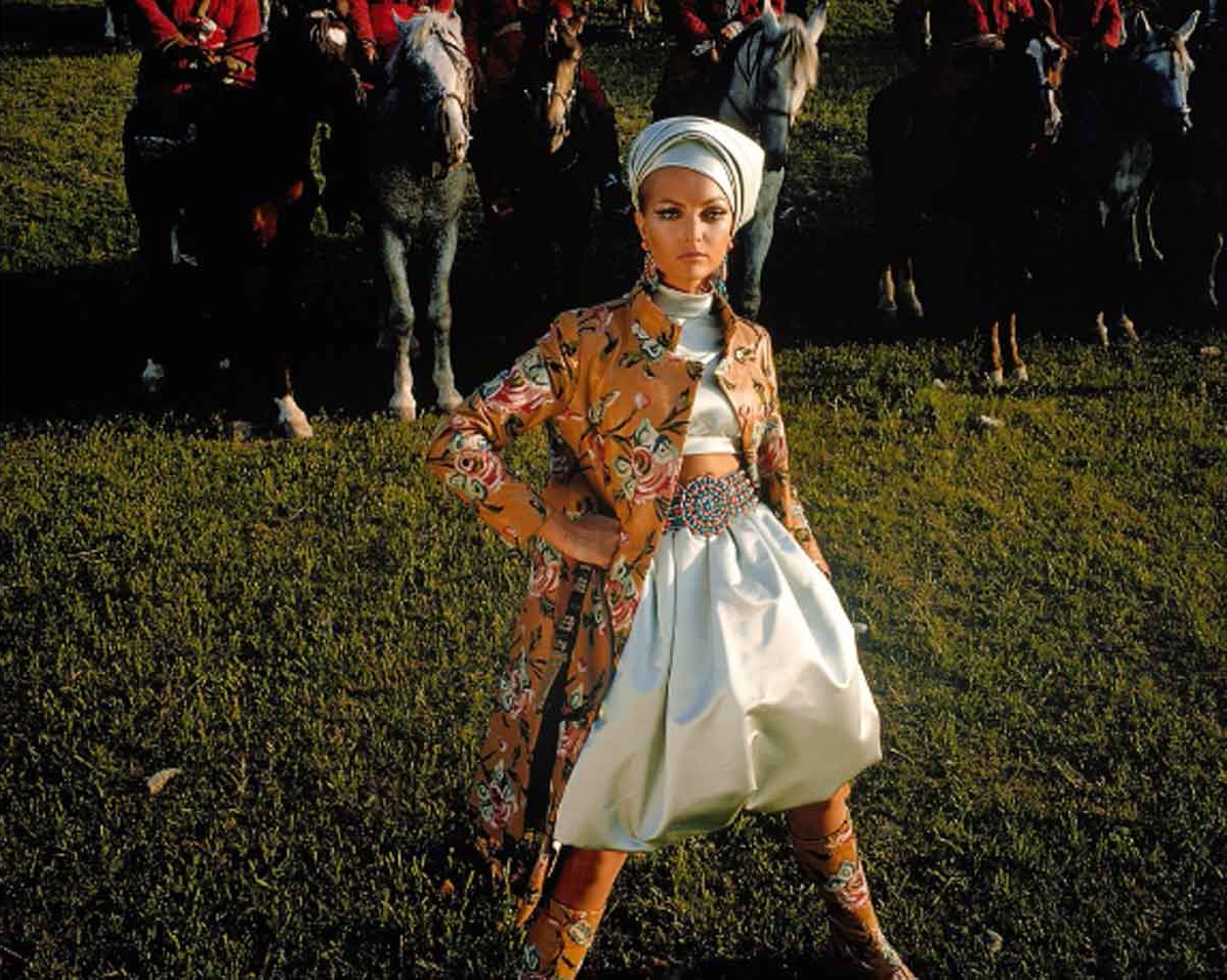 Model wearing a floral embroidered coat and turban.